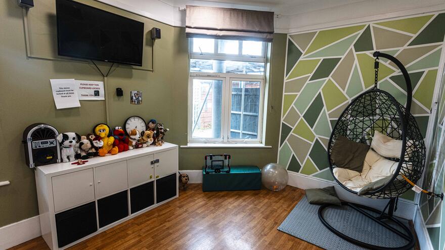 Dolphin Court house 1 sensory room with an egg chair and TV