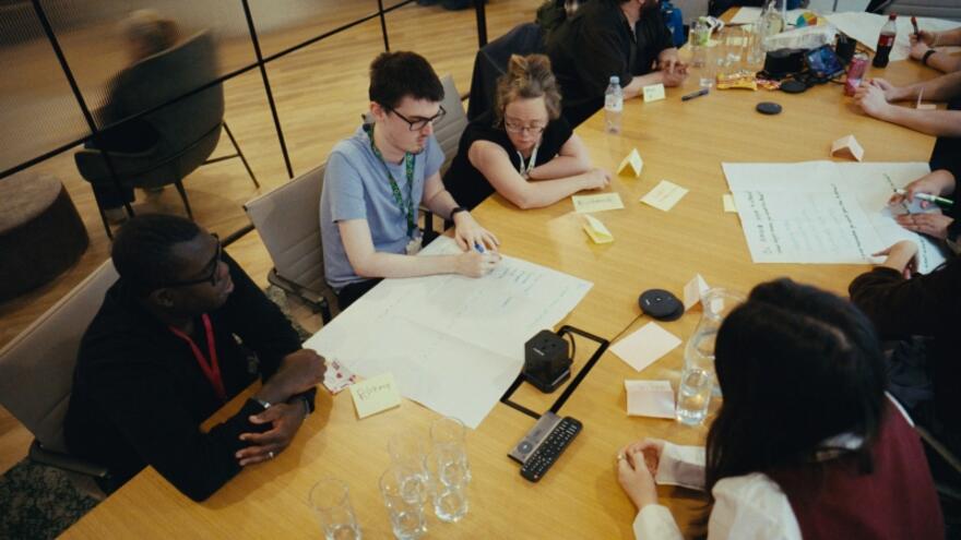 An overhead view of people sitting working at a meeting table