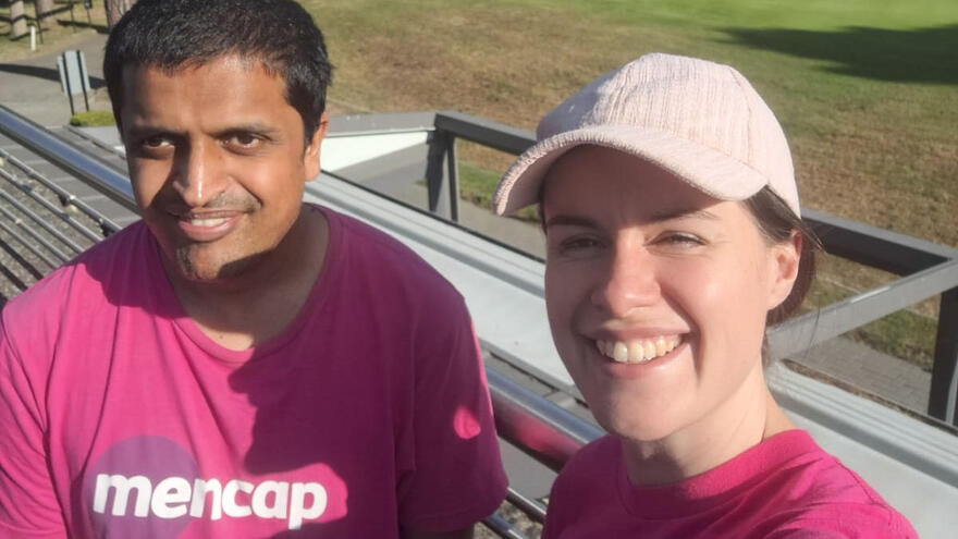 a man and a woman in pink mencap t-shirts smiling