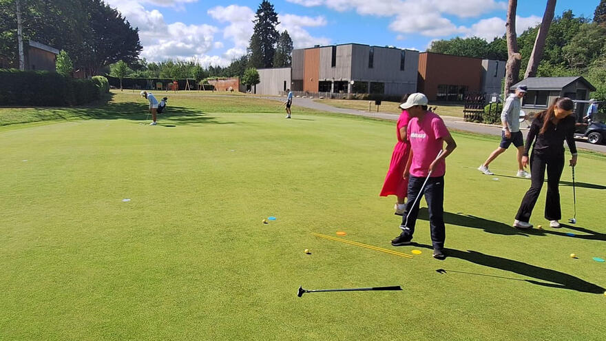 A man on a golf green putting