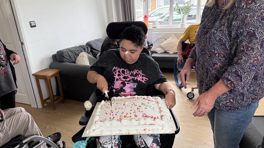 Lil, a Mencap Service User, cutting a cake