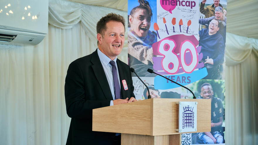Jon, Mencap's CEO, stood on stage delivering a speech.