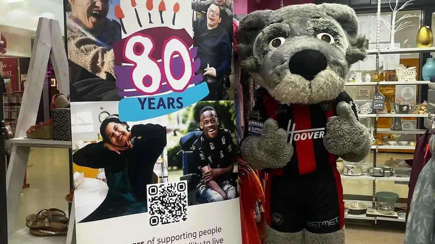 Warrington Wolves rugby team mascot visiting his local Mencap shop