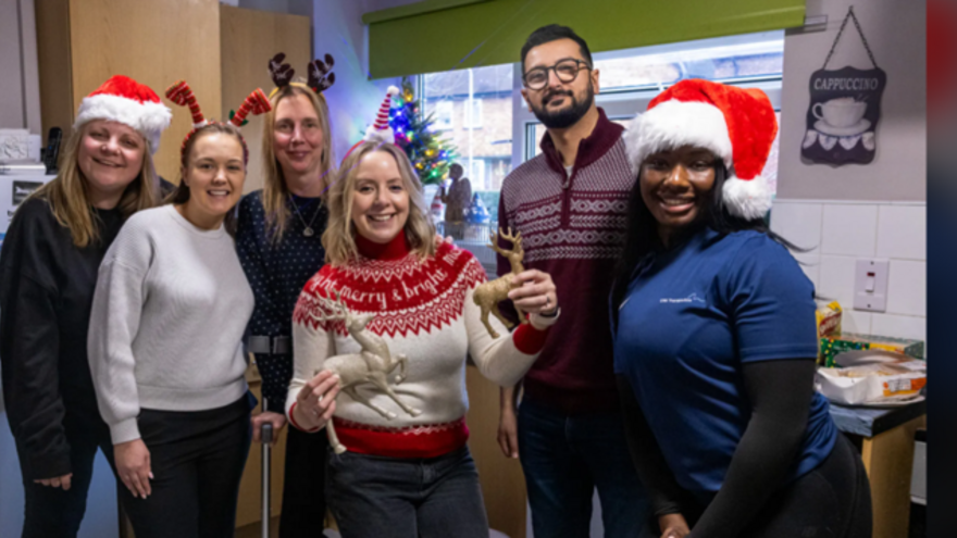 A group of people with Christmas hats and jumpers on