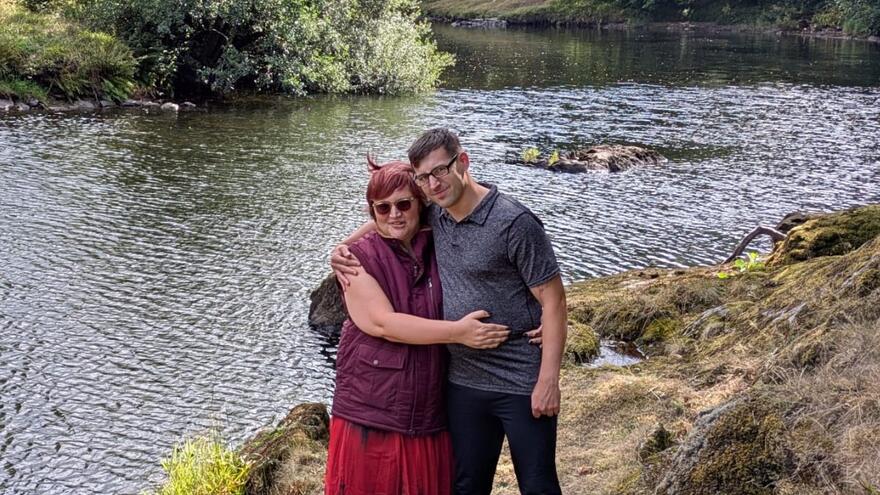 A man and woman hugging by a river