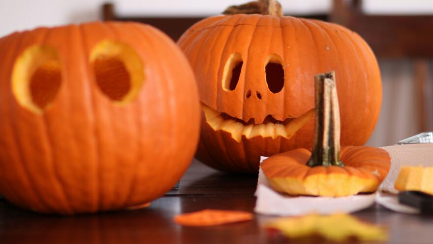 Two carved pumpkins on a table ready for Halloween