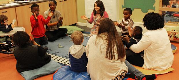 Adults leading sensory story telling session for children in nursery.