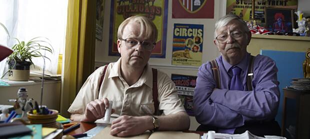 Two men sat together at table.