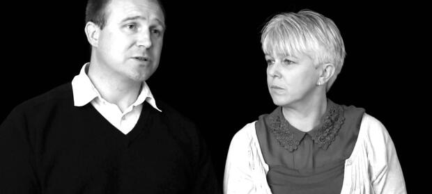 Black and white photograph of a man and woman sat next to each other.