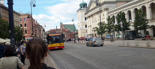 Road with cars and busses driving down it.