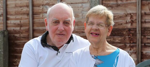 Older couple sat together in garden.