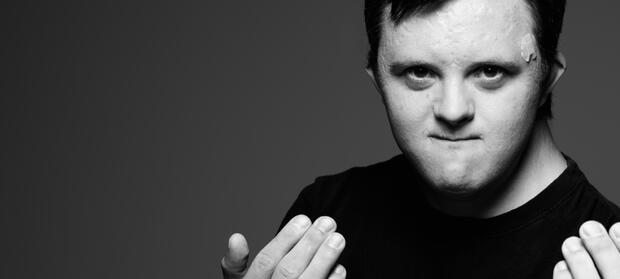 Young man looking into camera beckoning with his hands