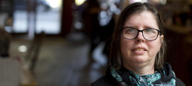 Woman with dark hair and glasses looking into camera