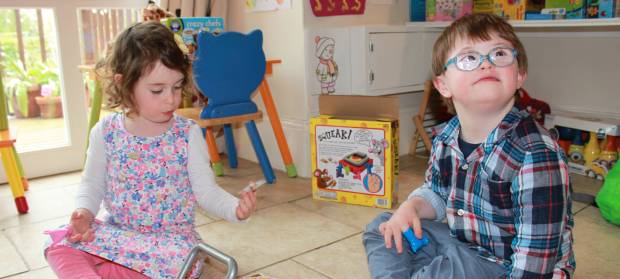 Two young children sat in a nursery playing with toys together