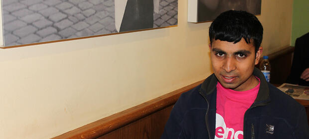 Man wearing Mencap t-shirt sat in coffee shop.