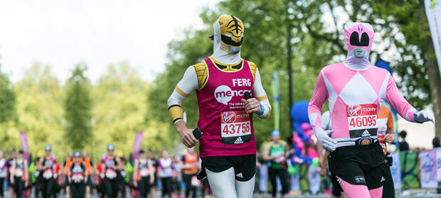Two people running wearing superhero costumes