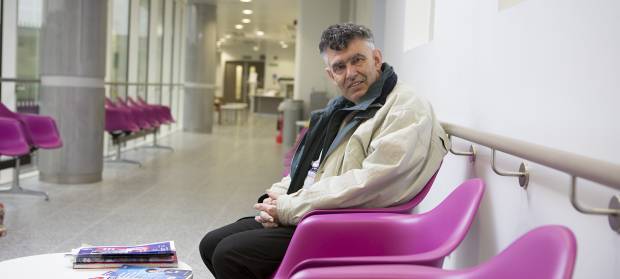 Older man sat in hospital corridor 