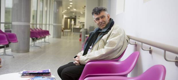Man sat in hospital waiting room smiling