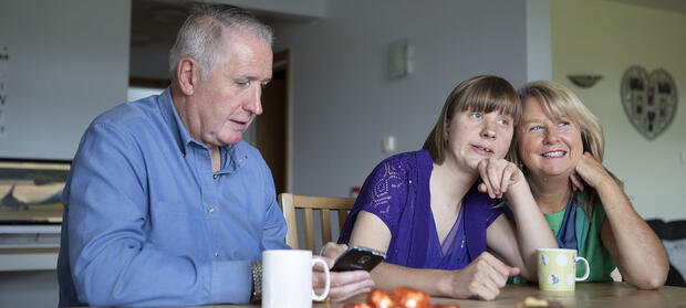Family sat together round dining table