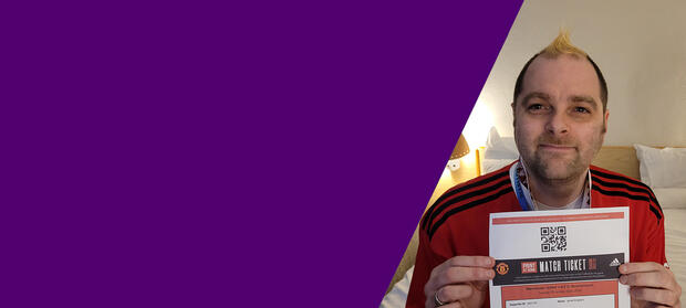A man holds up a paper ticket