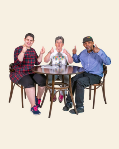 Three people at a round table with their thumbs up