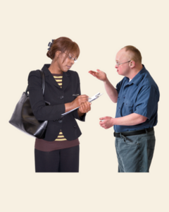 A man telling a woman who is writing in a note pad about problems with his healthcare