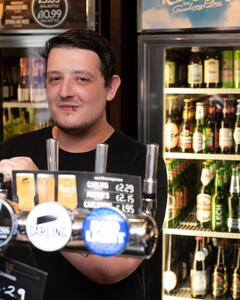 A man serving drinks at a bar.