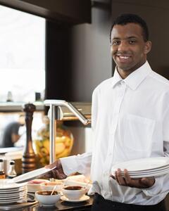 A man smiling and holding plates.