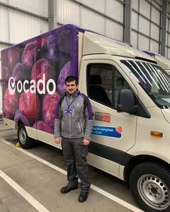 A man standing next to an Ocado delivery van
