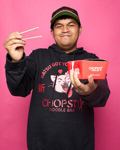 Arjhay holding a Chopstix meal box and chopsticks