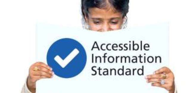 A woman holding up the Accessible Information Standard document
