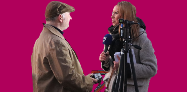 a reporter with a radio microphone talking to a man in a coat and hat